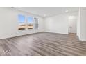 Spacious living room featuring gray vinyl plank flooring and large windows at 310 N Bur Oak Dr, Mooresville, IN 46158