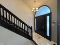 Elegant foyer featuring a dark wood staircase and chandelier lighting the entrance at 11720 Grenadier Ln, Indianapolis, IN 46229