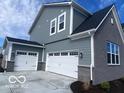 Exterior features a three car garage, stone and siding accents for enhanced curb appeal at 6596 Dogwood Dr, McCordsville, IN 46055