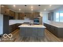 Modern kitchen features an island with pendant lighting, quartz countertops, and stainless steel appliances at 6596 Dogwood Dr, McCordsville, IN 46055