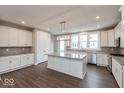 Bright kitchen featuring white cabinets, stainless steel appliances, a large island, and wood-look flooring at 7340 W County Road 600 Rd, McCordsville, IN 46055