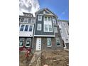 New construction townhome with brick facade, gray siding, and white trim under a cloudy sky at 7344 W County Road 600, McCordsville, IN 46055