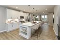 Bright open-concept kitchen boasts a large island with seating, sleek appliances, and ample storage at 7344 W County Road 600, McCordsville, IN 46055