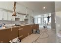 A work-in-progress kitchen featuring white cabinets, paint supplies, and a worker on a ladder at 7344 W County Road 600, McCordsville, IN 46055
