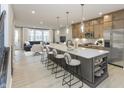 A spacious kitchen with a large island, modern appliances, and sleek countertops, open to a living area at 7348 W County Road 600 Rd # 12-604, McCordsville, IN 46055