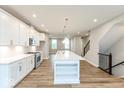 Modern kitchen features an island with quartz countertop and stainless steel appliances at 7352 W County Road 600, McCordsville, IN 46055
