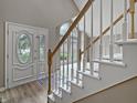 Bright entryway featuring an ornate front door, wood flooring, and a staircase with white and wood trim at 1242 Bitterwood Ct, Columbus, IN 47201