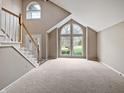 Spacious living room featuring high ceilings, large windows, and carpet flooring at 1242 Bitterwood Ct, Columbus, IN 47201