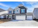 Two-story home boasts a three-car garage, gray siding, red shutters, and a well-lit, paved driveway at 67 Sterling Pl, New Whiteland, IN 46184