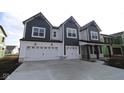 Beautiful new construction home with gray and white siding, a covered porch, and a three car garage at 10603 Banyan Wood Ct, Indianapolis, IN 46239