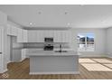 Bright kitchen features modern white cabinetry, stainless steel appliances, and an island with a sink at 3509 Wrangler Dr, Bargersville, IN 46106