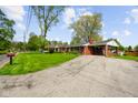 A single-story red brick house featuring an attached carport and a wide driveway at 56 Hadley Woodland St, Mooresville, IN 46158