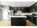 Modern kitchen with dark cabinetry, stainless steel appliances, and an island at 9426 Park Meridian Dr, Indianapolis, IN 46260