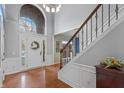 Bright entryway with hardwood floors, an arched window, and elegant staircase at 13886 Golden Saddle Ct, Carmel, IN 46032