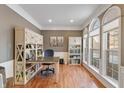 Home office with built-in shelving, hardwood floors, and large windows at 13886 Golden Saddle Ct, Carmel, IN 46032