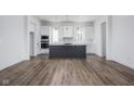 Open-concept kitchen with dark island, stainless steel appliances, white cabinetry, and hardwood floors at 17368 Pinellas Ave, Westfield, IN 46074