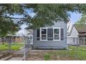 Charming blue house with black shutters and fenced yard surrounded by trees at 2218 N Arsenal Ave, Indianapolis, IN 46218
