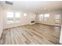 Spacious living room featuring modern wood flooring, a sleek fireplace, and abundant natural light at 3922 Holly Brook Dr, Westfield, IN 46062