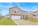 Two-story house with tan siding, brick accents, and a two-car garage at 8414 Ingalls Way, Camby, IN 46113
