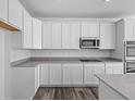 Bright kitchen featuring white cabinetry, modern appliances, and gray countertops at 16892 Cattle Hollow Ln, Noblesville, IN 46060