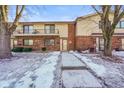 Brick front exterior of twin home with balcony and snowy landscaping at 23 Trails End St, Greenwood, IN 46142