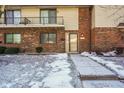 Brick front exterior of twin home with balcony and snowy landscaping at 23 Trails End St, Greenwood, IN 46142