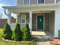 Inviting front porch with stone accents, white columns, and a well-manicured lawn featuring shrubs at 672 Rocky Meadow Dr, Greenwood, IN 46143