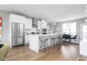 Open concept kitchen with island, stainless steel appliances, and hardwood floors at 9895 Baneberry Ln, Carmel, IN 46290