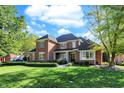 Charming two-story brick home with a well-maintained lawn, complemented by lush landscaping at 3441 S Overlook Pass, New Palestine, IN 46163