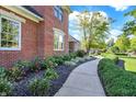 Landscaped walkway leads to a traditional brick home with well-maintained gardens and trimmed hedges at 3441 S Overlook Pass, New Palestine, IN 46163