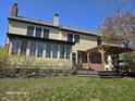 View of the home's exterior featuring a sunroom with many windows, a deck, and a pergola at 8429 Admirals Cv, Indianapolis, IN 46236