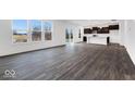 Open-concept living space showcasing wood floors connecting to the kitchen and dining area at 1082 Stubble Run, Danville, IN 46122