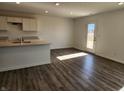 Open concept kitchen with an island, modern countertops, and a door to the backyard at 3211 W Keepsake Ln, Monrovia, IN 46157