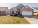 Inviting single-story home showcases a well-maintained front yard, brick facade, and attached two-car garage at 5677 Starla Ln, Plainfield, IN 46168