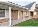 Inviting front porch showcasing brickwork, white columns, and windows with shutters at 2856 Jamieson Ln, Indianapolis, IN 46268
