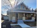 Light green craftsman home with a covered porch and detached garage at 5009 E Michigan E St, Indianapolis, IN 46201