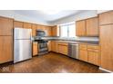 Well-lit kitchen features stainless steel appliances and ample wood cabinetry with tile floors at 7027 Creekside Ln, Indianapolis, IN 46220