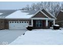 Brick ranch home with attached garage, covered porch, and snow covered yard at 154 Darrough Dr, Greenwood, IN 46143