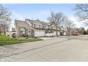 View of townhouses with attached garages and well-manicured lawns at 5845 Shipwatch Pl, Indianapolis, IN 46237