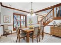 Traditional dining room features a wood table, six chairs, decorative light fixture, and staircase in an inviting space at 11469 Woodview Ct, Fishers, IN 46038
