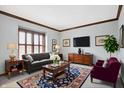 Elegant living room with tufted sofa, area rug, shuttered window, and a flat screen tv at 11469 Woodview Ct, Fishers, IN 46038
