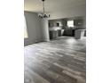Open-concept living space with modern gray flooring and a stylish light fixture at 1433 Wigwam Ln, Martinsville, IN 46151