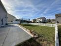 Wide backyard view with green grass, concrete patio, bordered by a white picket fence, providing a serene outdoor space at 5128 Macaferty St, Plainfield, IN 46168