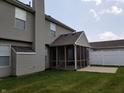 Backyard featuring a screened-in porch and concrete patio, perfect for outdoor entertaining and relaxation at 6442 E Flat Rock Dr, Camby, IN 46113