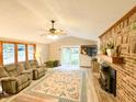 Inviting living room with brick fireplace, ceiling fan, and sliding glass doors to the backyard at 797 S Graveyard Rd, Paragon, IN 46166