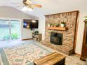Bright living room showcasing a brick fireplace, ceiling fan, and sliding glass door to the backyard at 797 S Graveyard Rd, Paragon, IN 46166