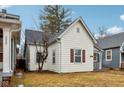 Home featuring white siding, red window trim, gray roof, and manicured yard at 2521 Prospect St, Indianapolis, IN 46203