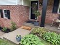 Inviting front entrance with brick exterior, black accents, and a welcoming 'welcome' mat at 454 Tulip Dr, Mooresville, IN 46158