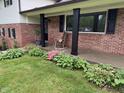 Charming front porch with brick facade, black shutters, and a cozy rocking chair at 454 Tulip Dr, Mooresville, IN 46158