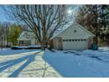 Tan brick ranch home with attached two car garage, winter view at 6361 Crystal Springs Dr, Avon, IN 46123